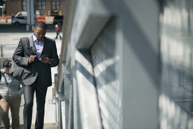 Man in suit walking in city with phone