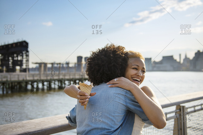 Couple embracing and laughing on city pier
