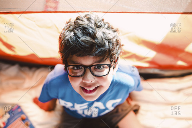 A boy smiles in an indoor tent