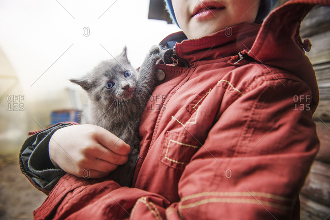 Boy holding a kitten in Sparks Lake, Central Oregon