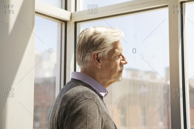 Senior man staring out the window