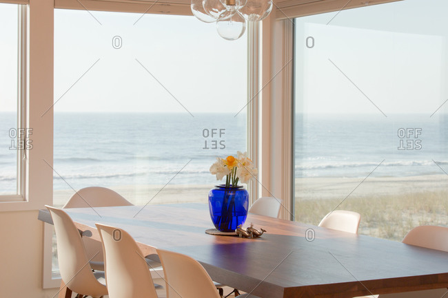 Flowers on table in dining room with an ocean view