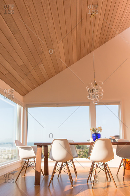 Modern dining table below a sloping ceiling in a modern beach house