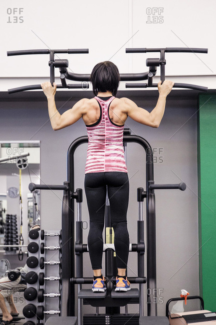 Rear view of sporty woman exercising at health club