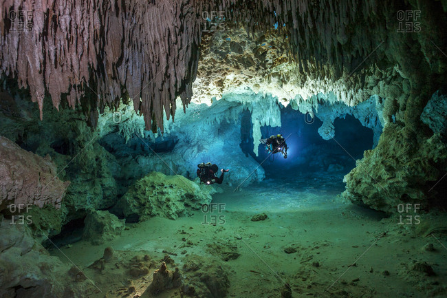 Two cave divers exploring the cave system of Cenote Chan Hol, Tulum