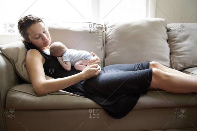 Young mother holds her sleeping newborn