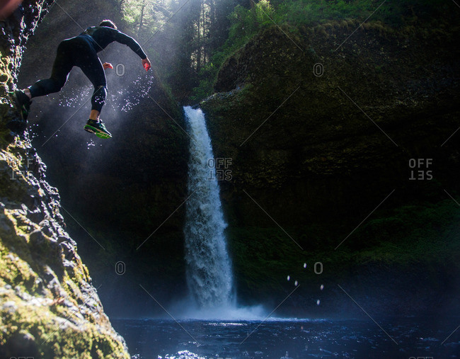 A man jumps into a swimming hole at Eagle Creek Falls in the Columbia Gorge, Oregon