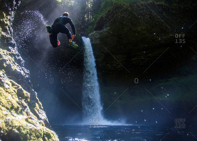 A man leaps into a swimming hole at Eagle Creek Falls in the Columbia Gorge, Oregon