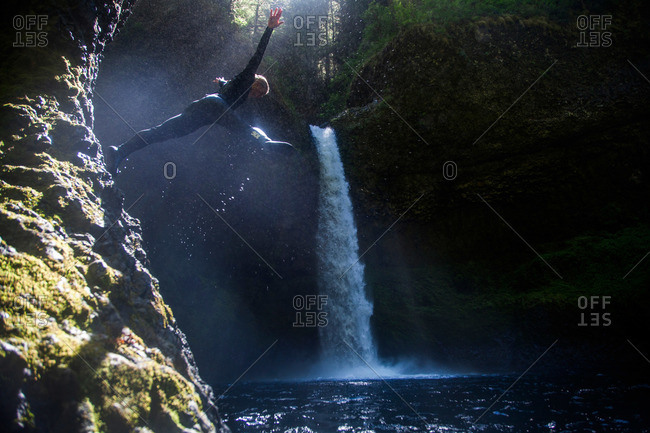 A woman leaps into a swimming hole at Eagle Creek Falls in the Columbia Gorge, Oregon