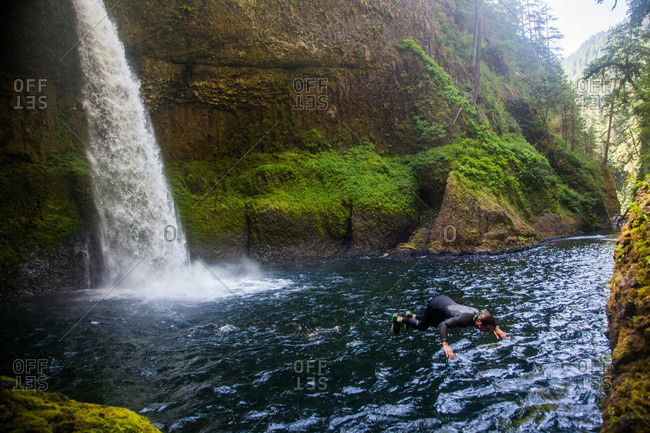 A man falls to the water at a swimming hole at Eagle Creek Falls in Columbia Gorge, Oregon