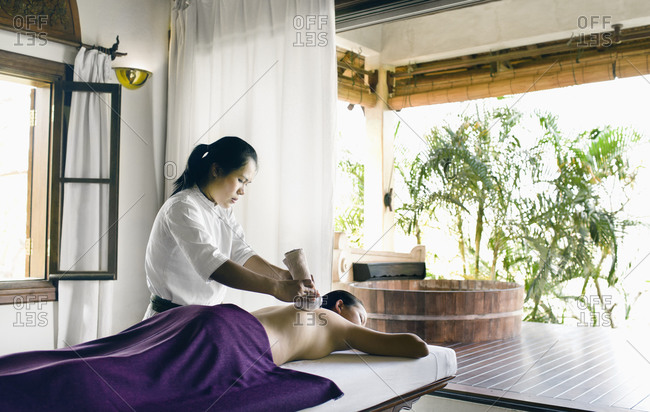Massage therapist applies a herbal compress, Luang Prabang, Laos