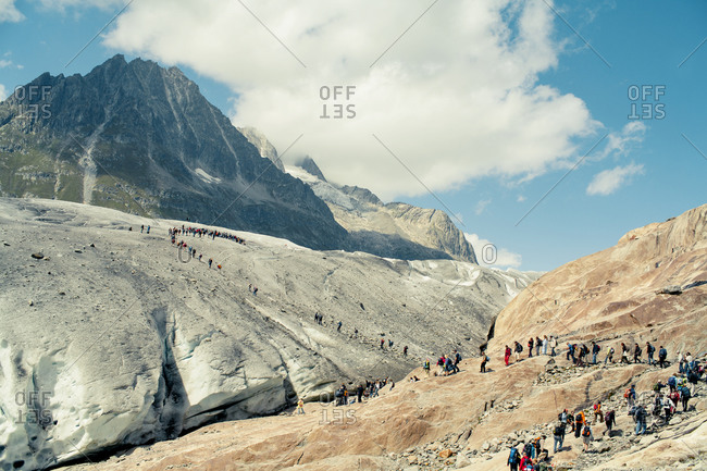Tourists hike along a mountain path