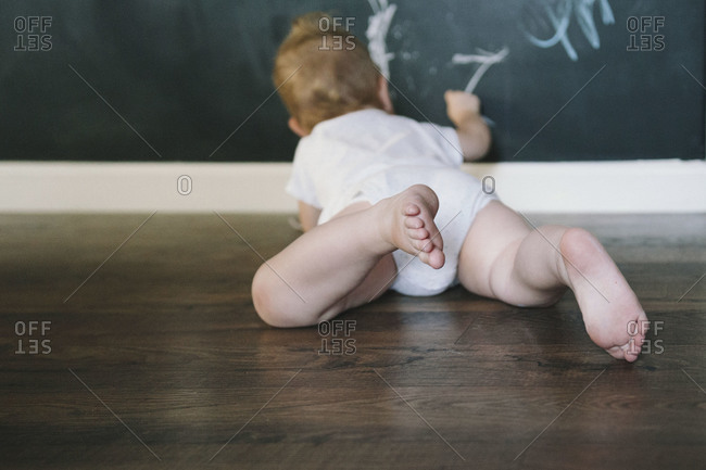 Baby drawing on chalkboard