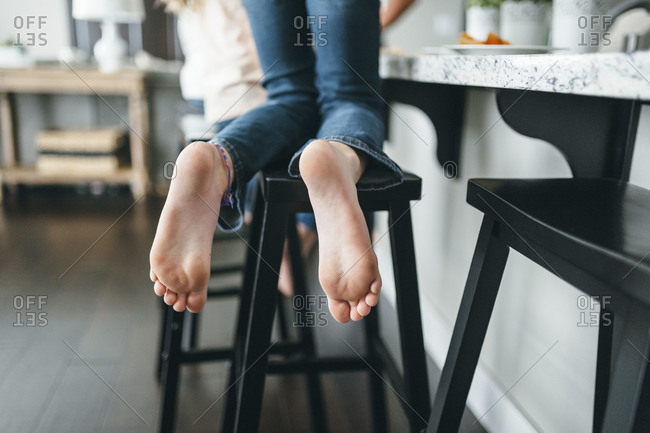 Feet of a girl kneeling on a stool