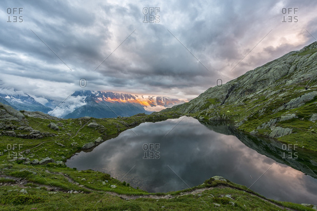 Mont Blanc reflected in the lake in a stormy day at sunset