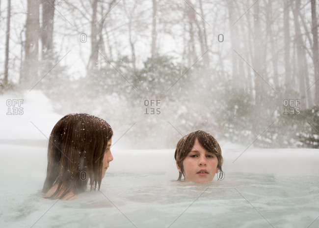Two kids in a hot tub in winter