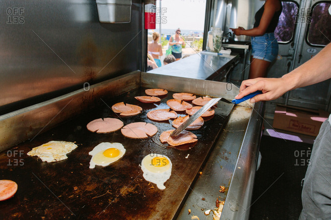 Cooking eggs and bologna in food truck