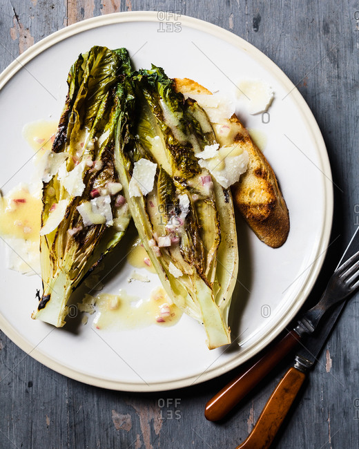Grilled romaine with cheese and dressing and slice of toast