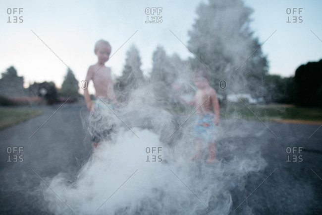Boys stand in the smoke of a novelty firework