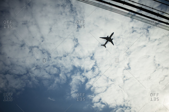 Plane flying overhead against cloudy sky