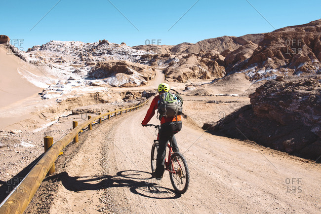 Man riding a mountain bike through the Valle de la Luna, Atacama Desert