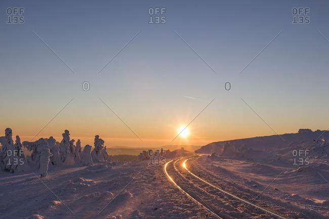 Rail tracks of Harz Narrow Gauge Railway in winter against the evening sun, Harz National Park