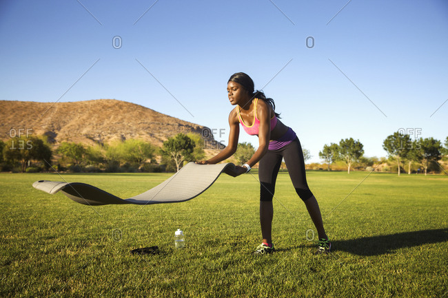 Athletic woman laying out yoga mat