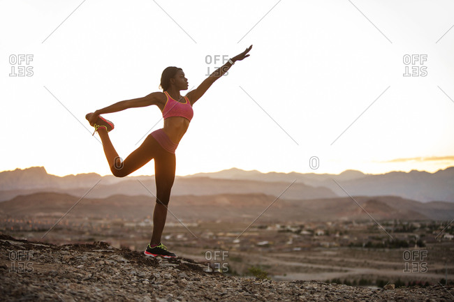 Woman on desert hill in yoga stance