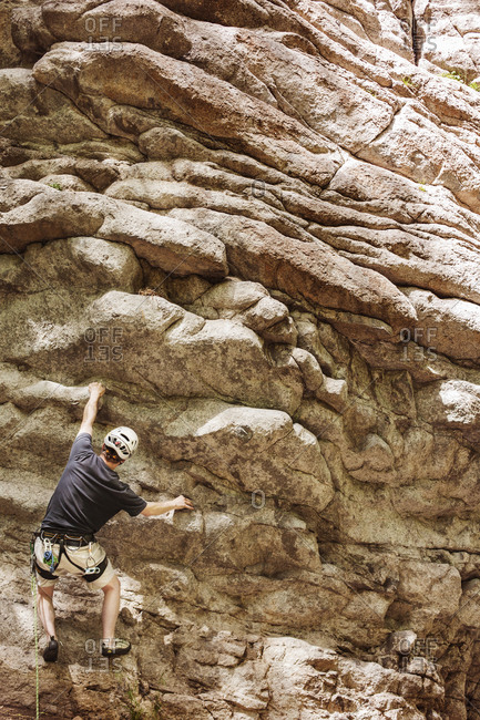 Rock climber making his way up cliff