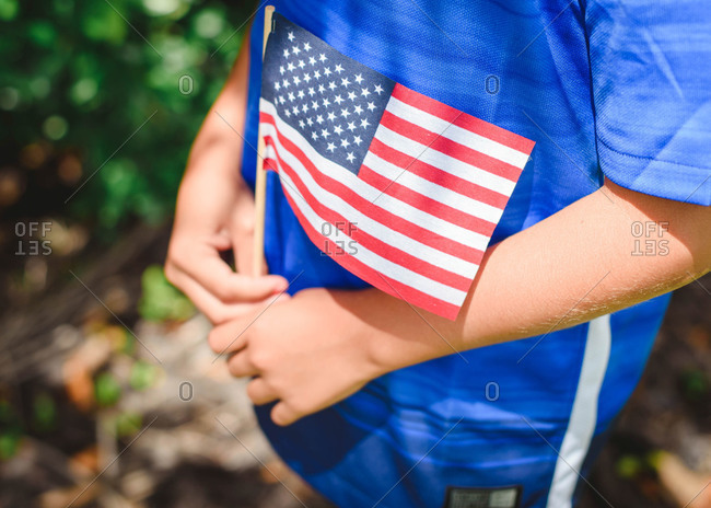 Close up of a young child\'s hands holding an American Flag