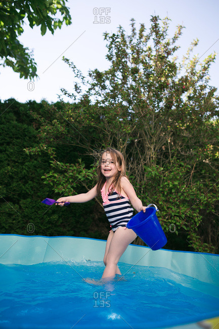 Little girl getting into kiddie pool