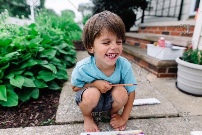 Boy sitting outside painting