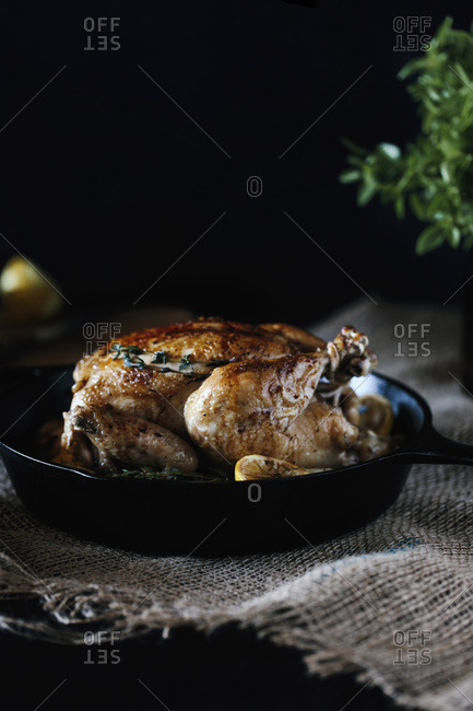 A roasted lemon chicken in a cast iron skillet