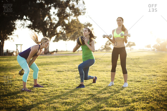 Three women participate in a fitness boot camp