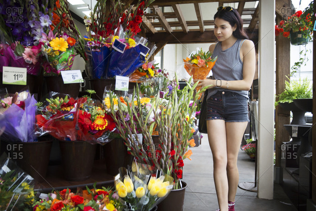 A young woman picks out flowers at a flower shop