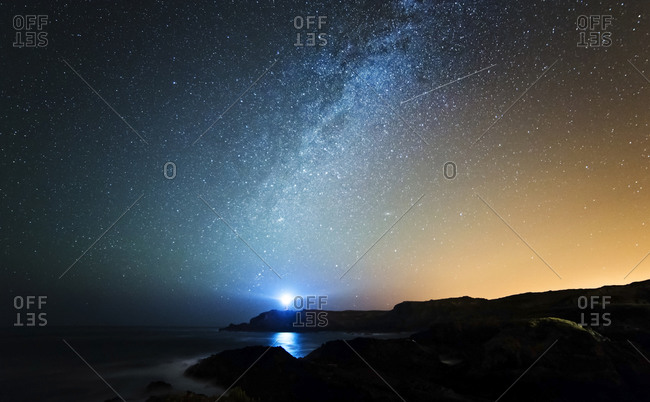 Starry sky with milky way and shooting star above the Galician coast