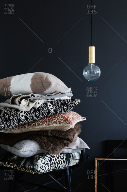 A stack of throw pillows in a black room