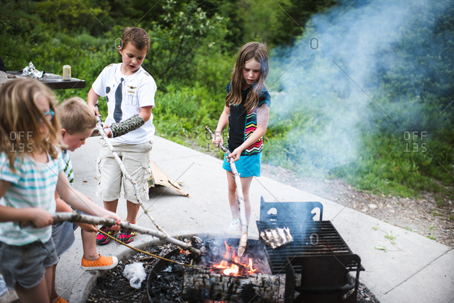 Children grill at a campground fire