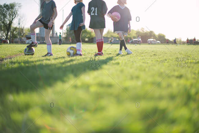 Young girls in soccer cleats standing on field