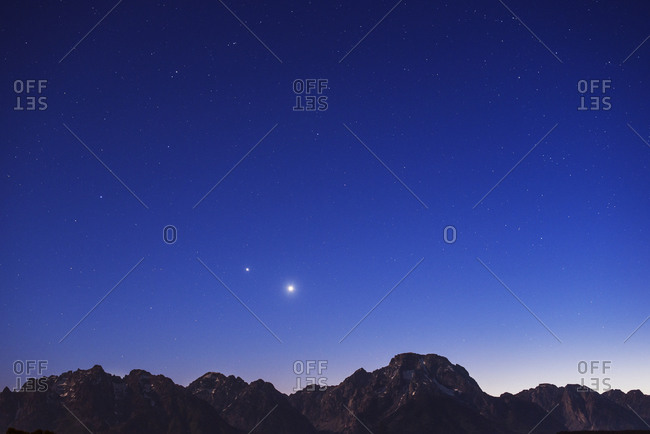 Stars in the night sky above mountain range
