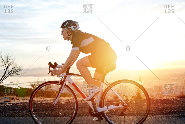 Woman cyclist riding a bike in sunlight