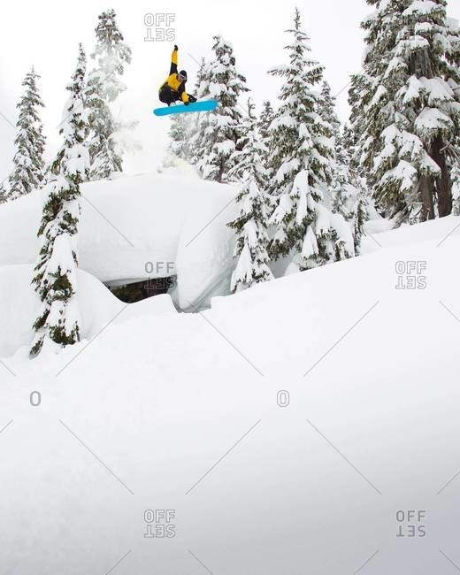 Snowboarder grabbing his board mid-air