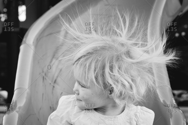 Little girl on slide with hair electrified with static electricity