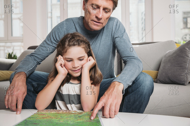 Father and little daughter with map in the living room