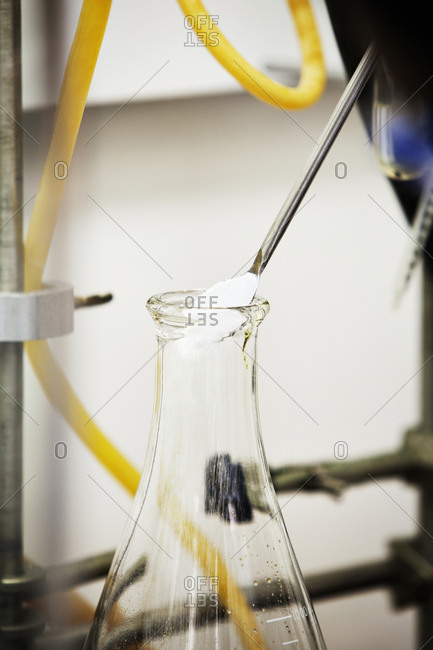 Powder pouring into a glass beaker