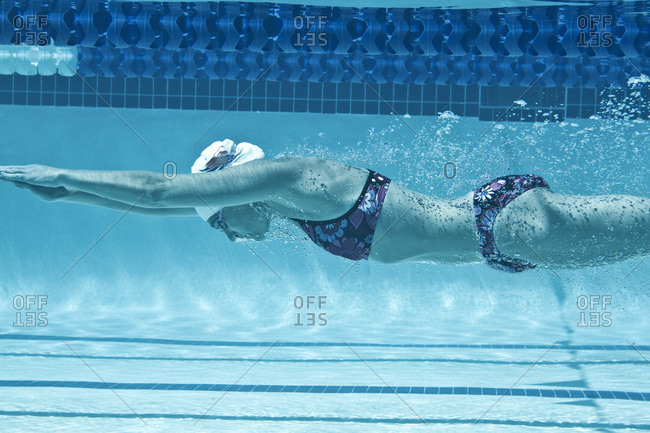 Swimmer underwater pushes off wall in swim lane