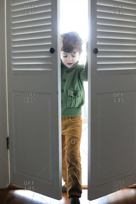 Boy pushing open closet doors