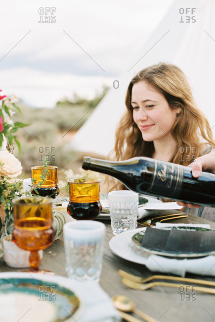 Woman pouring red wine from a bottle