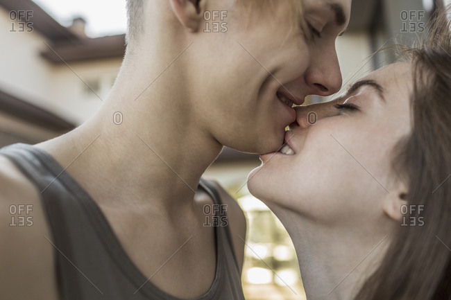 Side view of passionate woman biting man\'s chin