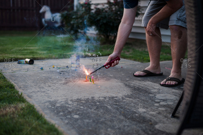 Man lighting firecrackers on a patio